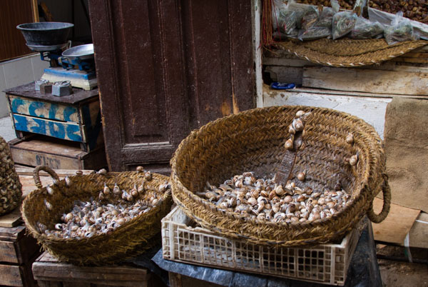 snails are sold by weight; note the balance scale in the background